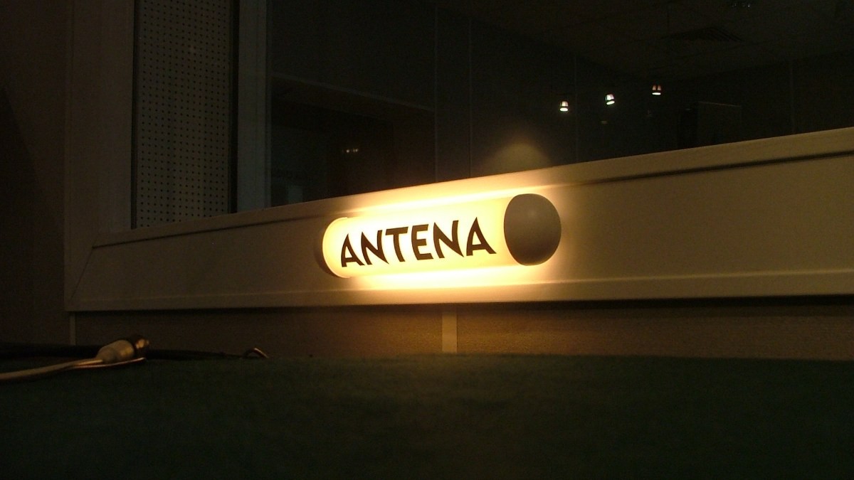 Piloto luminoso con la palabra «Antena» encendido en un estudio de radio a oscuras.